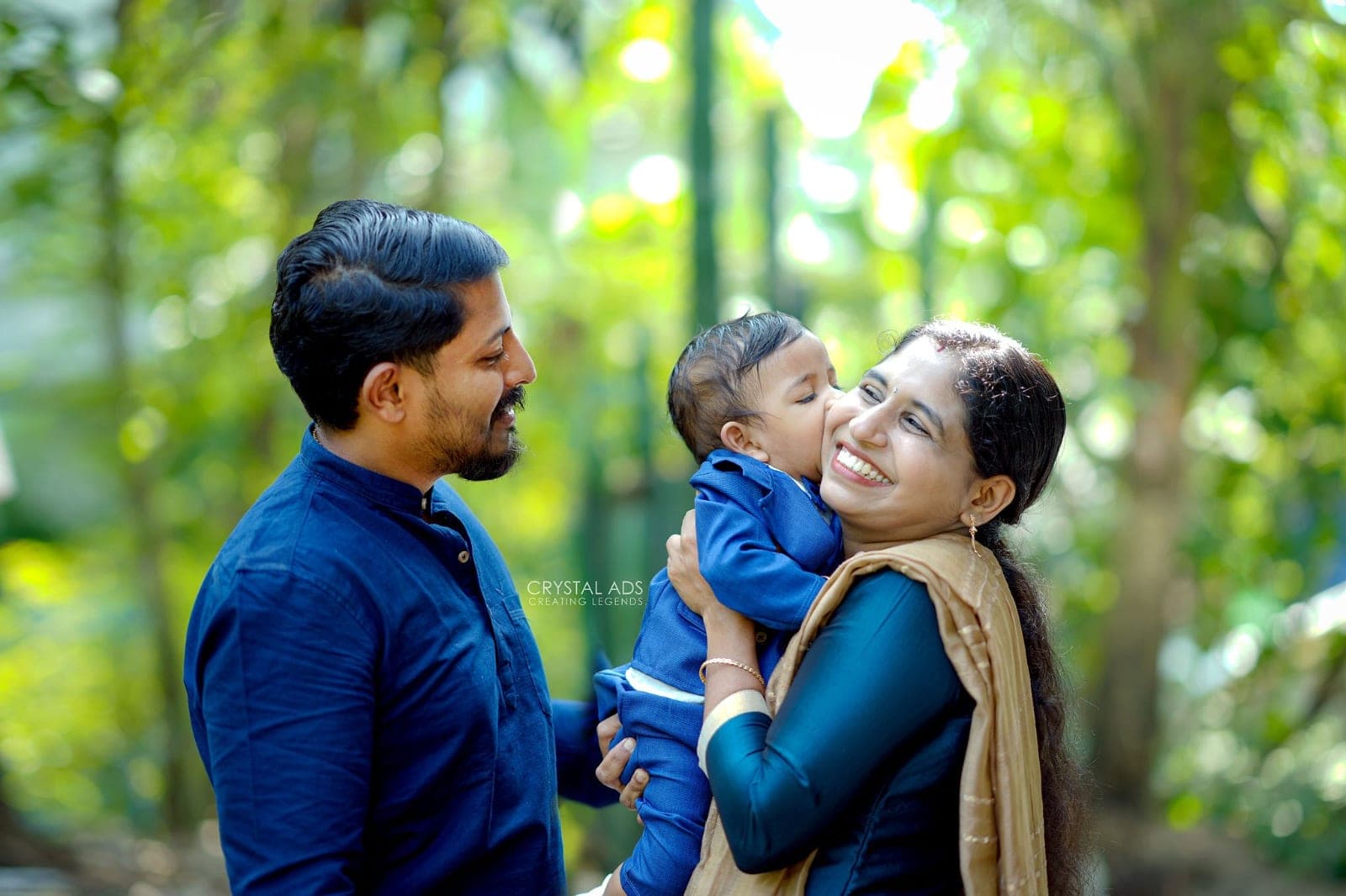 Baby kissing his mother's cheek as his father looks on
