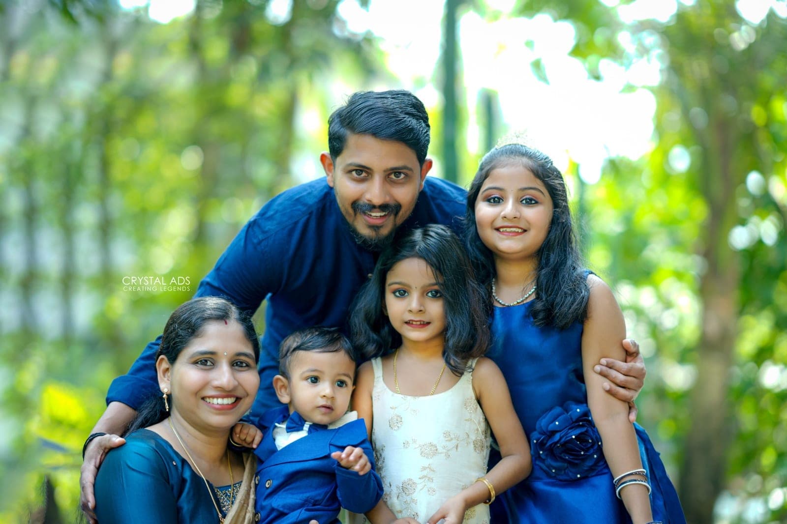 Family of five smiling together outdoors