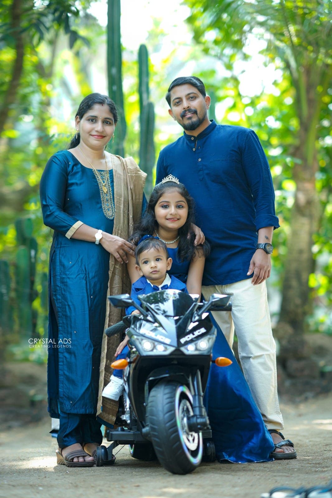 Family standing behind the baby on his toy motorbike