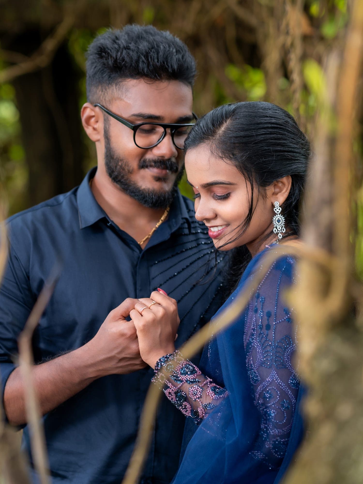 Engaged couple in matching navy outfits, sharing a close moment