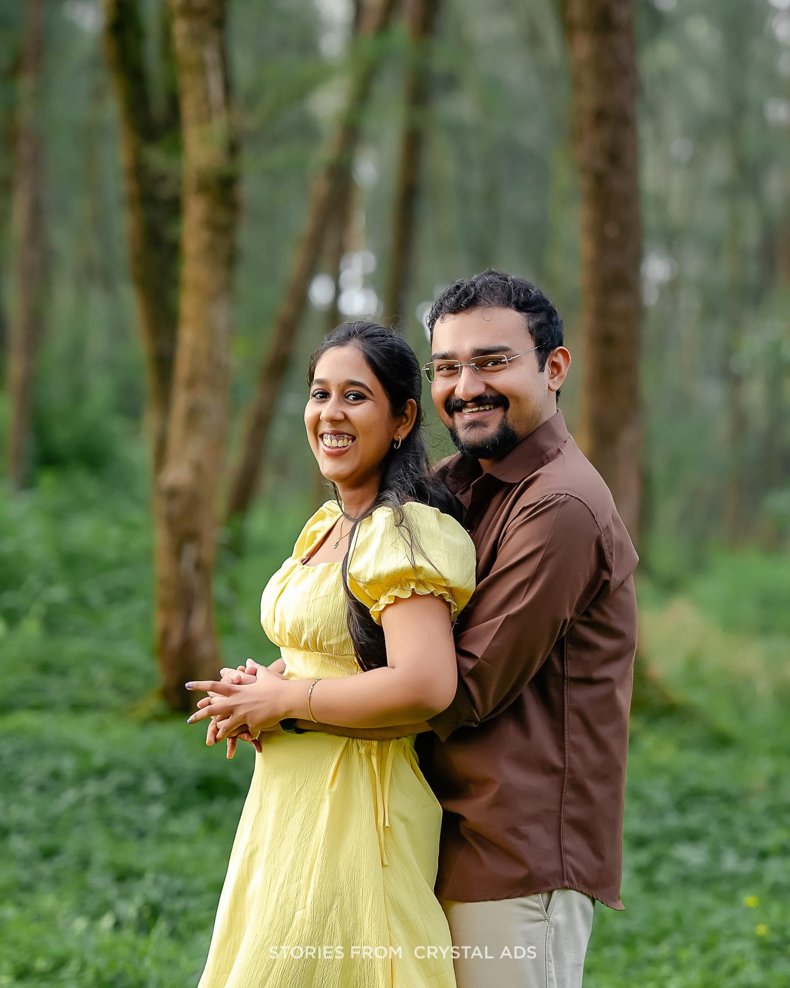 Couple laughing together, embracing in a forest