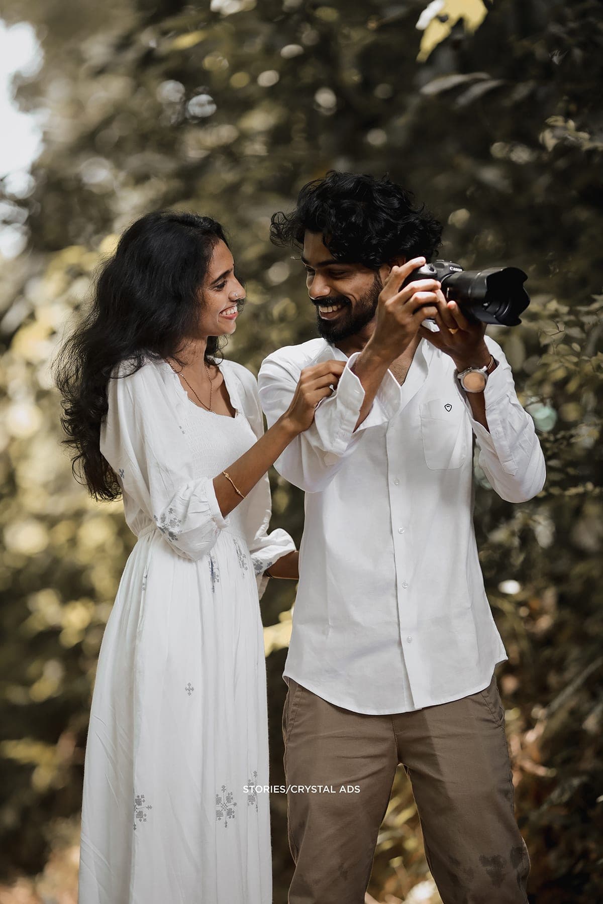 He shows her the camera as she leans in