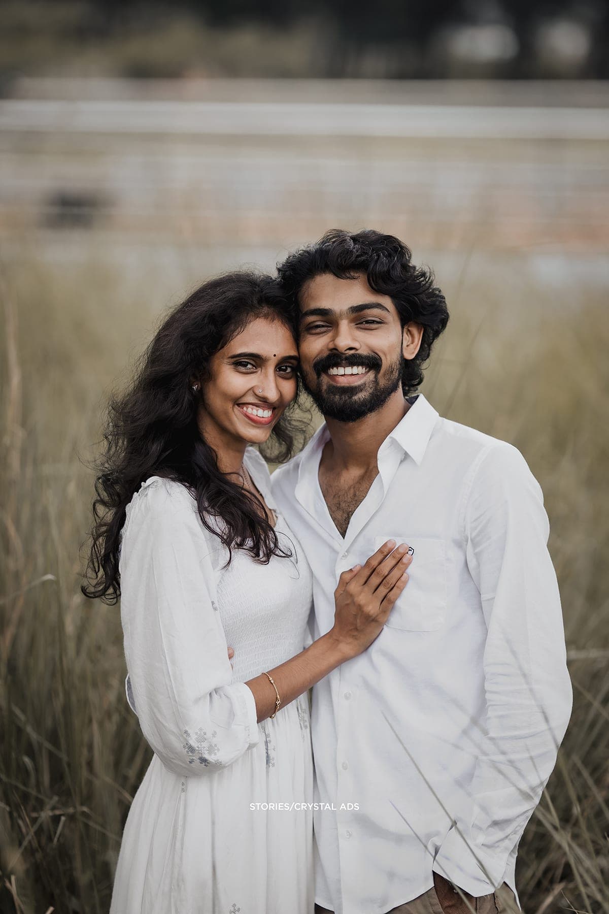Couple smiling at the camera, her hand on his chest