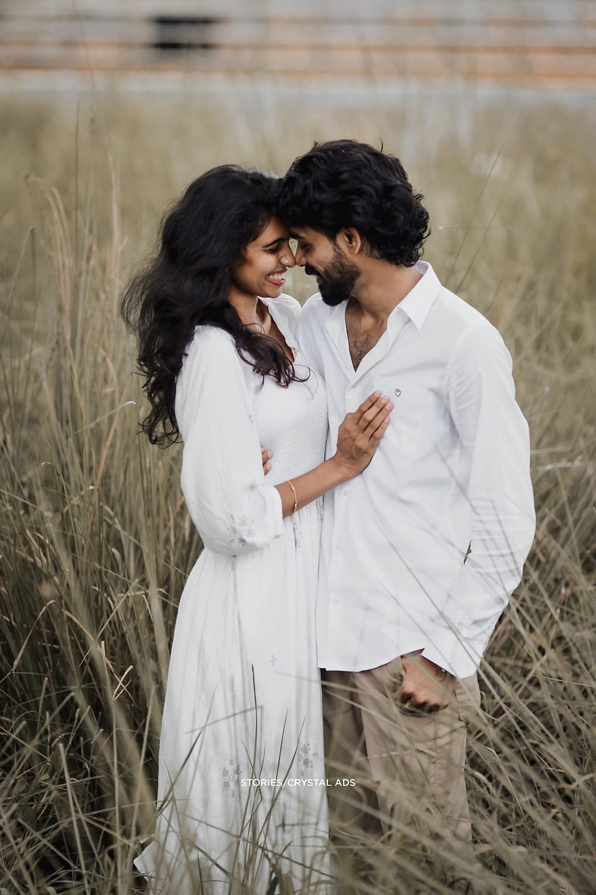 Couple with foreheads touching in the tall grass