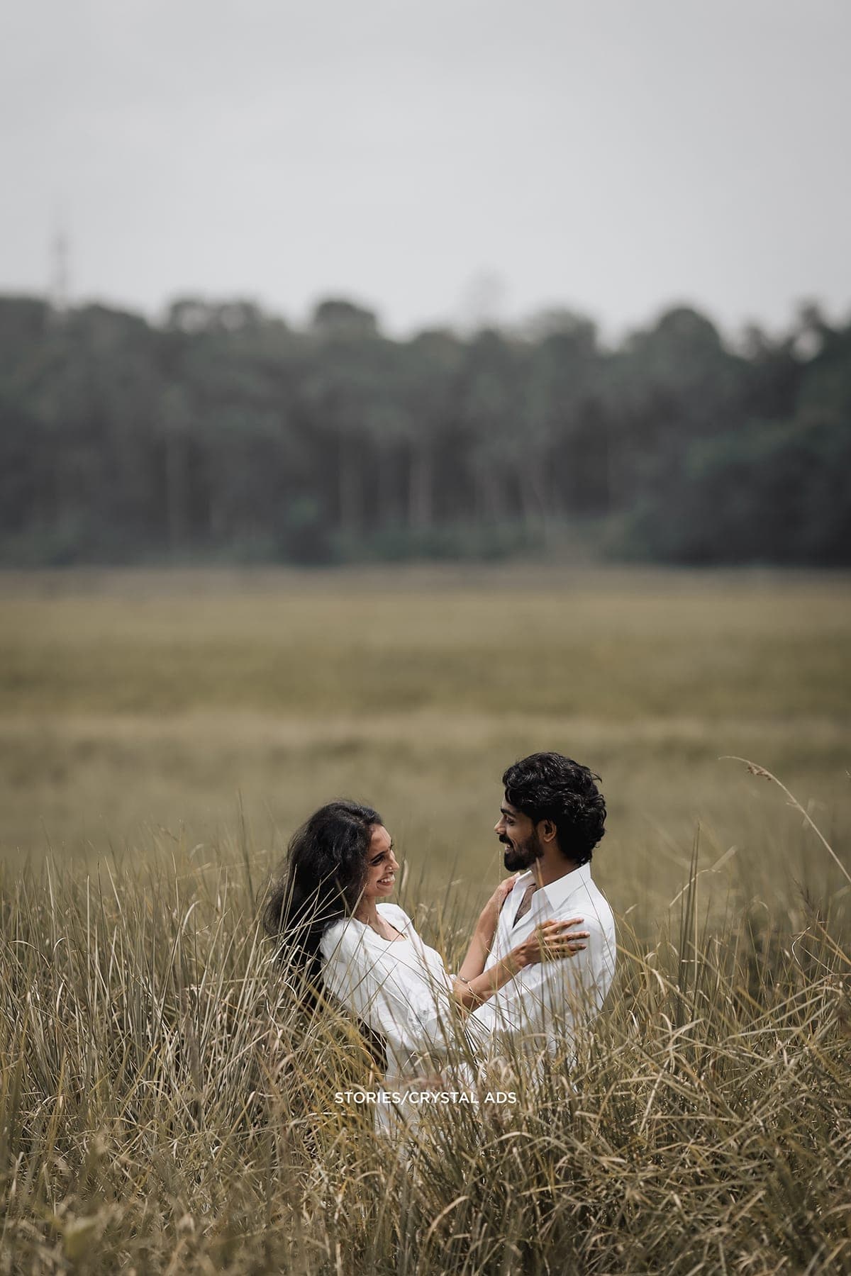 Couple half-hidden in tall grass, facing each other