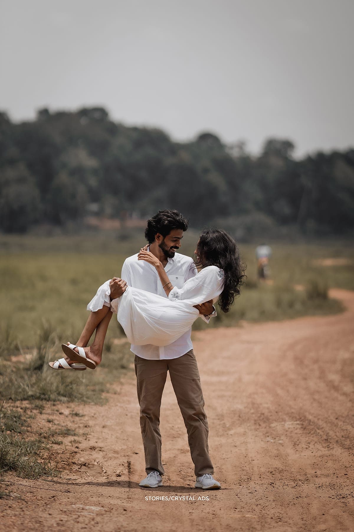He carries her along a dirt path