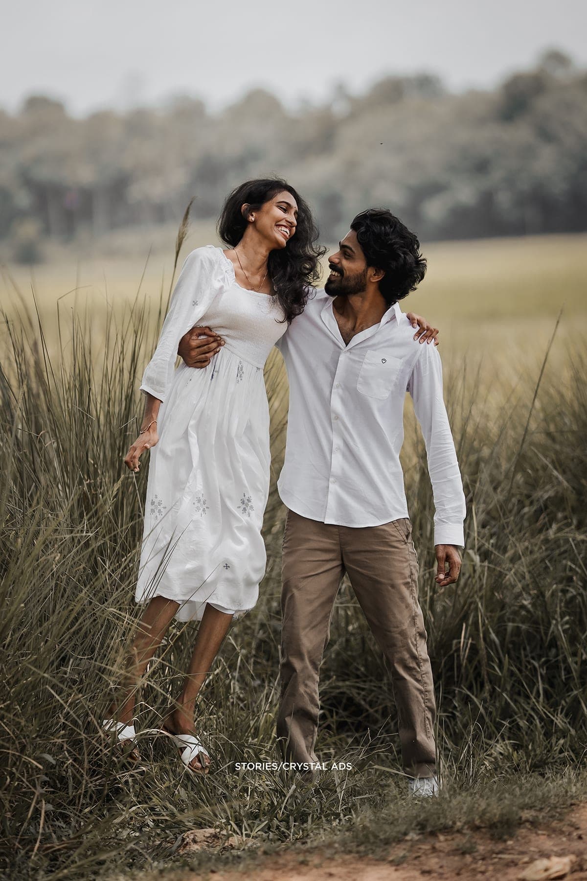 Couple walking arm in arm on the path, laughing