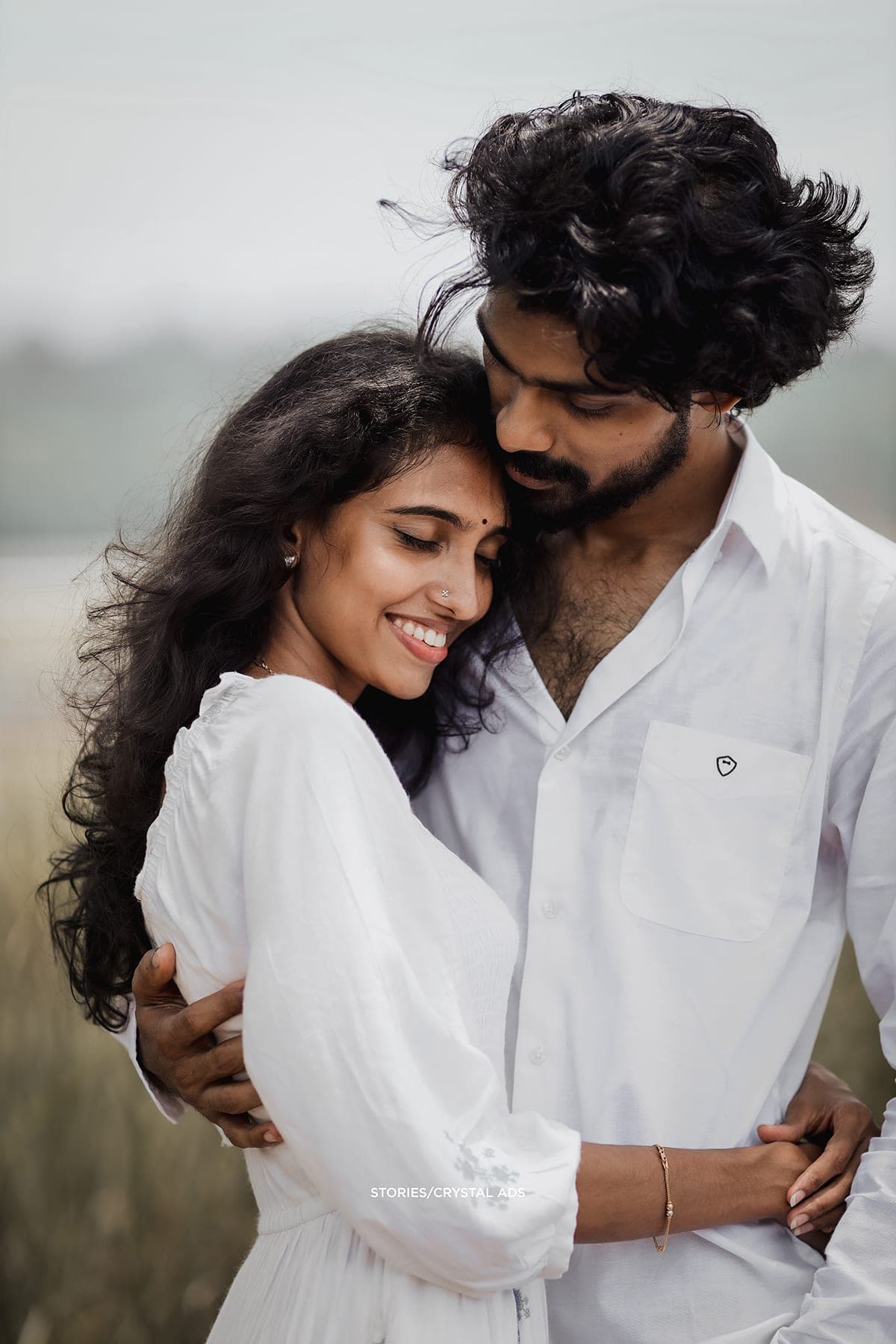 Close portrait, she smiles as he rests his head against hers