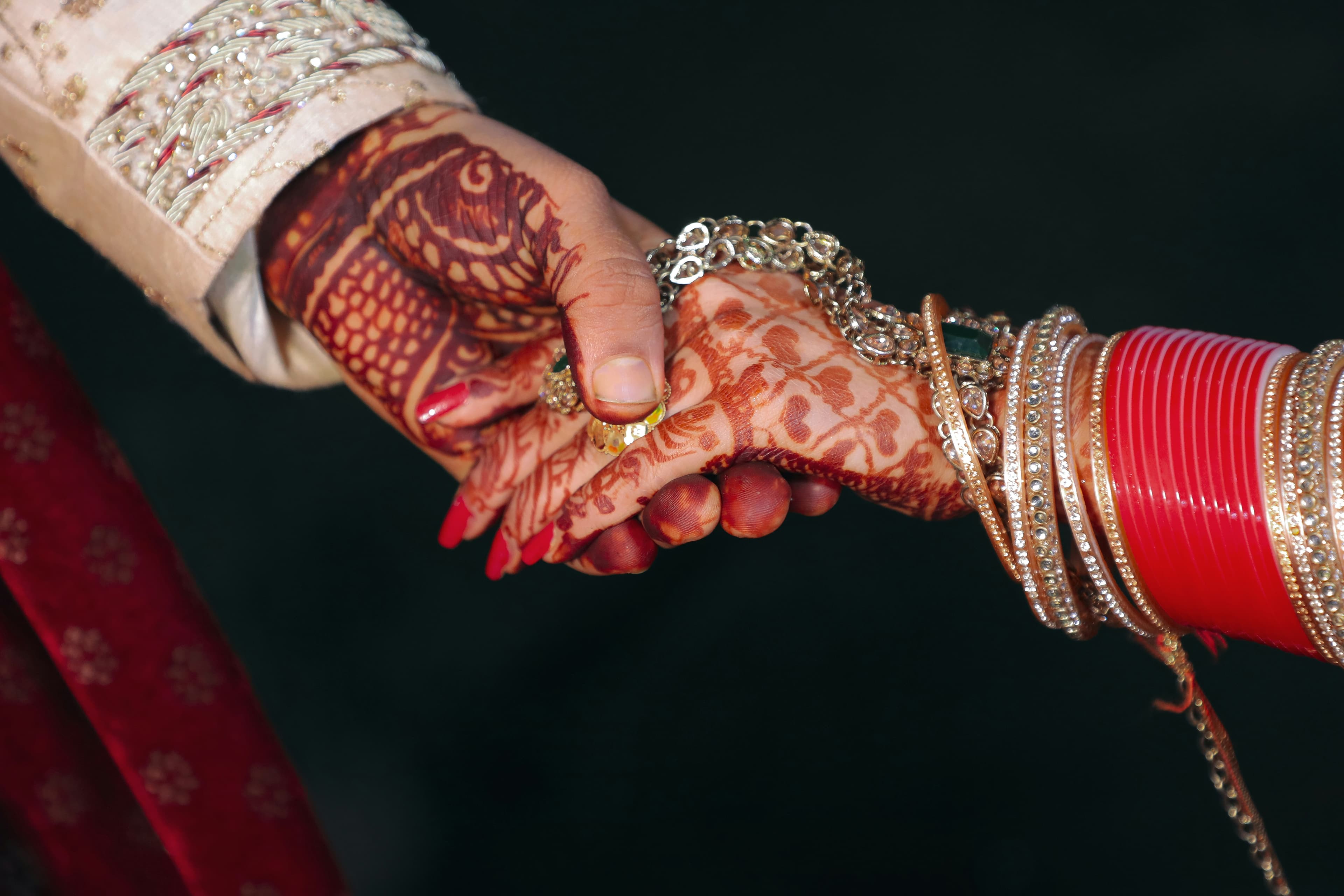 Close-up of hands with bridal henna and bangles