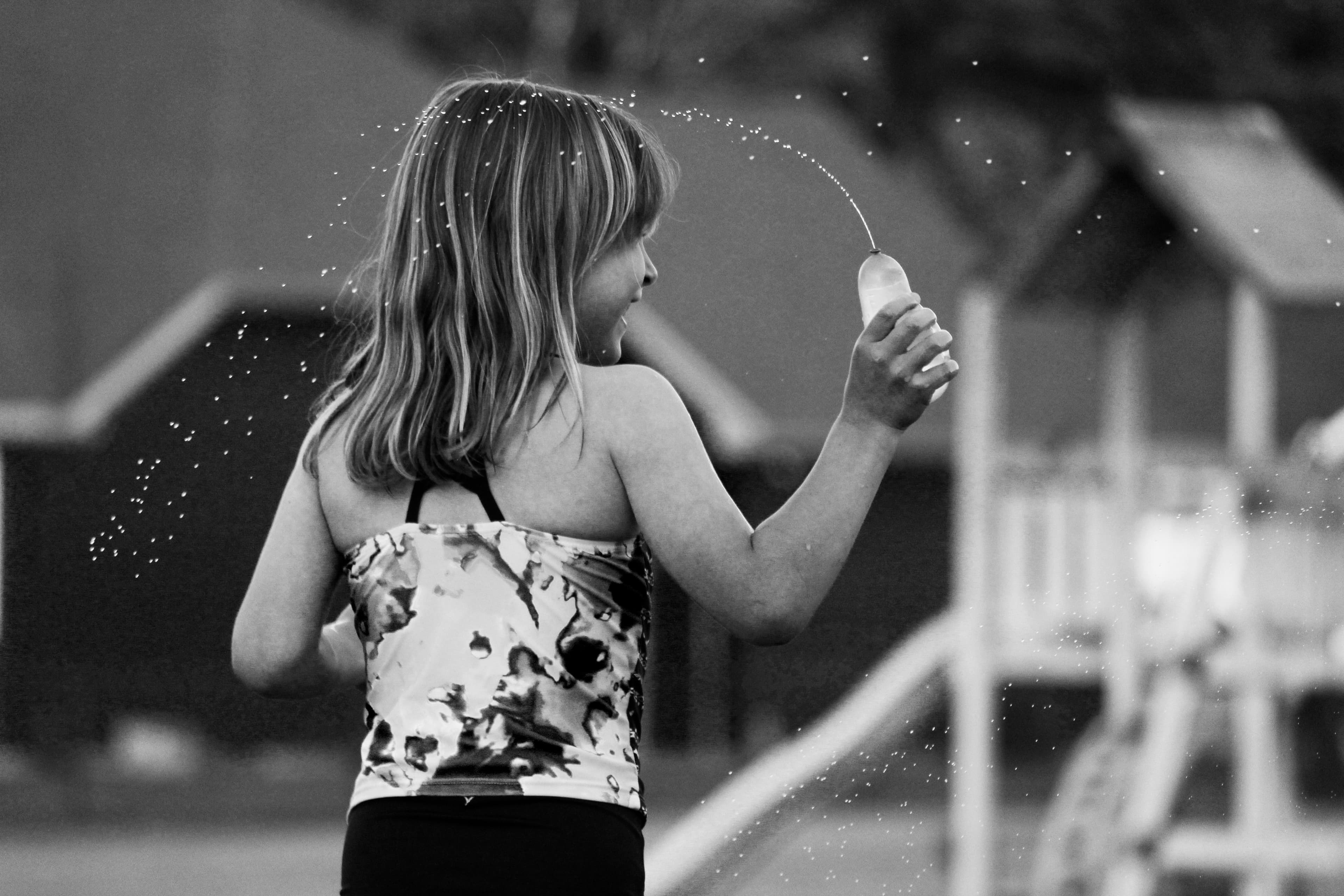 Young girl in a floral top holding a dandelion