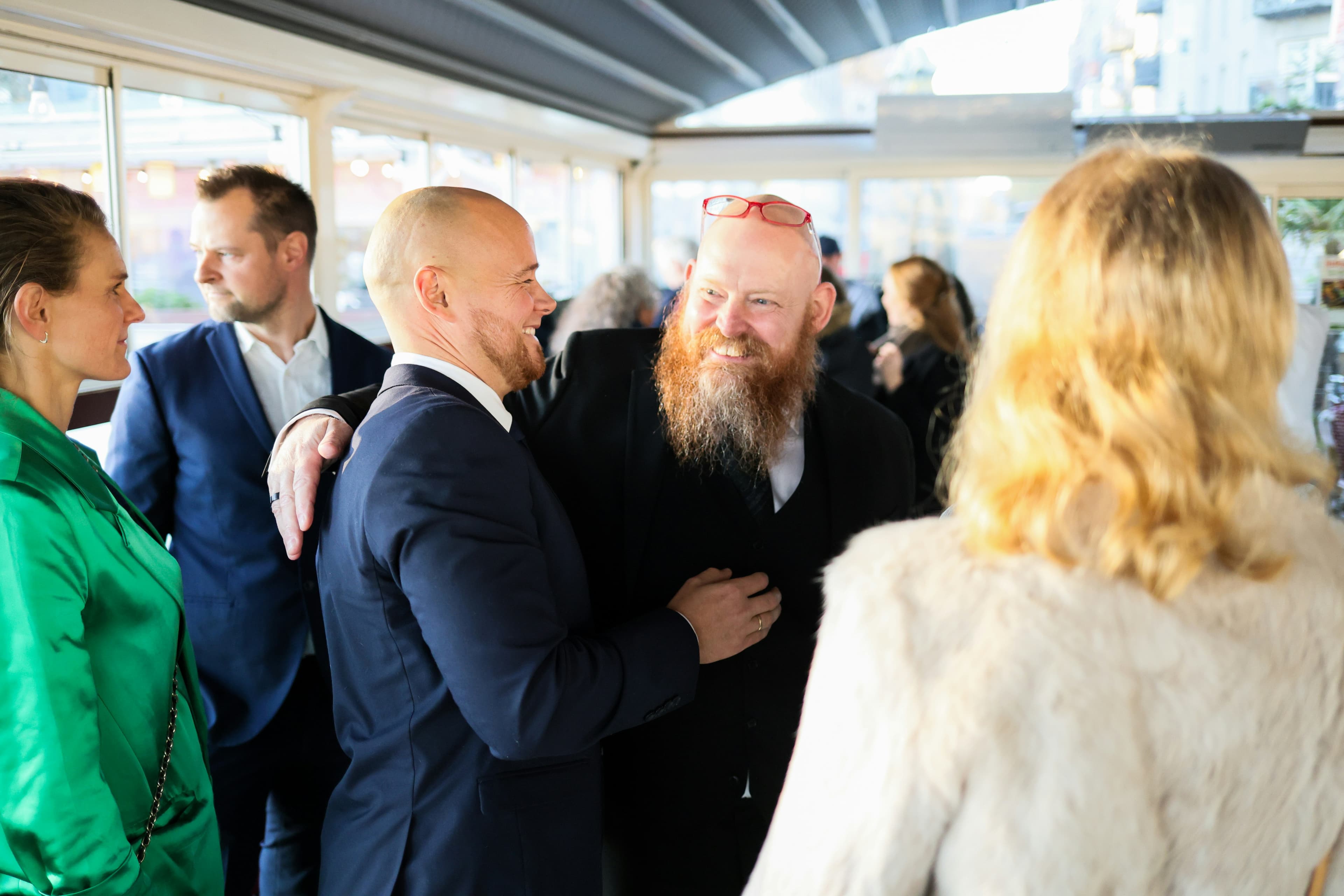 Two people greeting each other warmly at an event